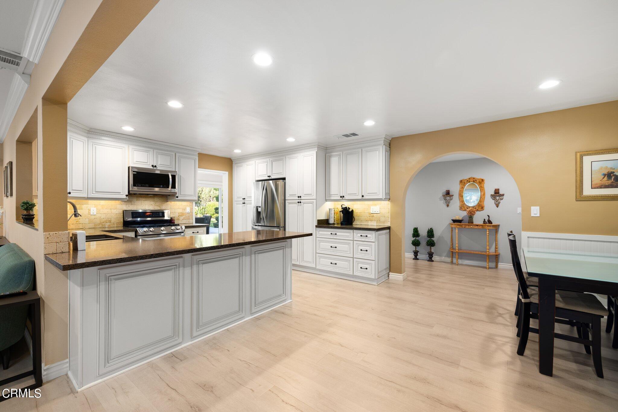 9356 Skyview Terrace Tujunga, CA 91042 - Photo 14 of 39 a kitchen with stainless steel appliances a sink a stove a refrigerator cabinets and a dining table
