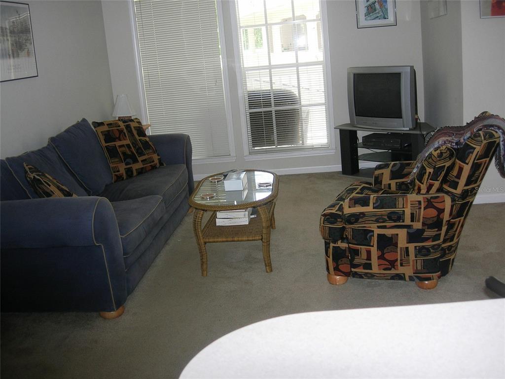 571 Water Street, Unit 571 Celebration, FL 34747 - Photo 11 of 26 a living room with furniture a flat screen tv and a window