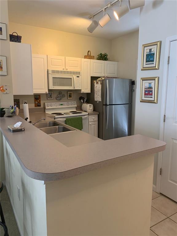 571 Water Street, Unit 571 Celebration, FL 34747 - Photo 16 of 26 a kitchen with kitchen island a sink appliances and cabinets