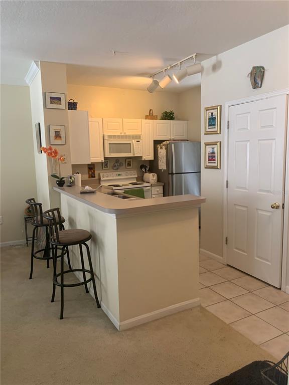 571 Water Street, Unit 571 Celebration, FL 34747 - Photo 2 of 26 a kitchen with kitchen island a counter top space a sink appliances and cabinets