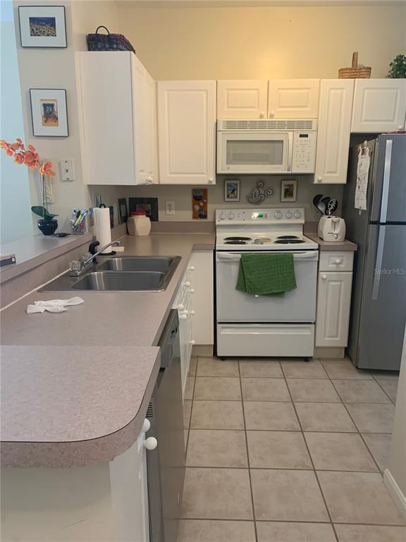 571 Water Street, Unit 571 Celebration, FL 34747 - Photo 8 of 26 a kitchen with stainless steel appliances a sink a stove a refrigerator and cabinets