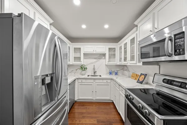 a kitchen with stainless steel appliances a refrigerator sink and stove