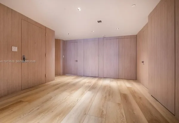 en empty room with wooden floor and windows
