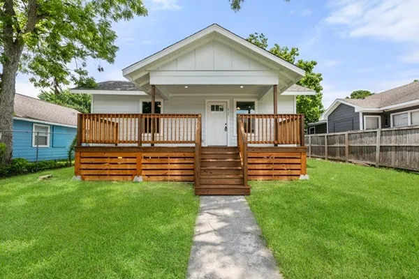 a view of a house with a small yard and wooden fence