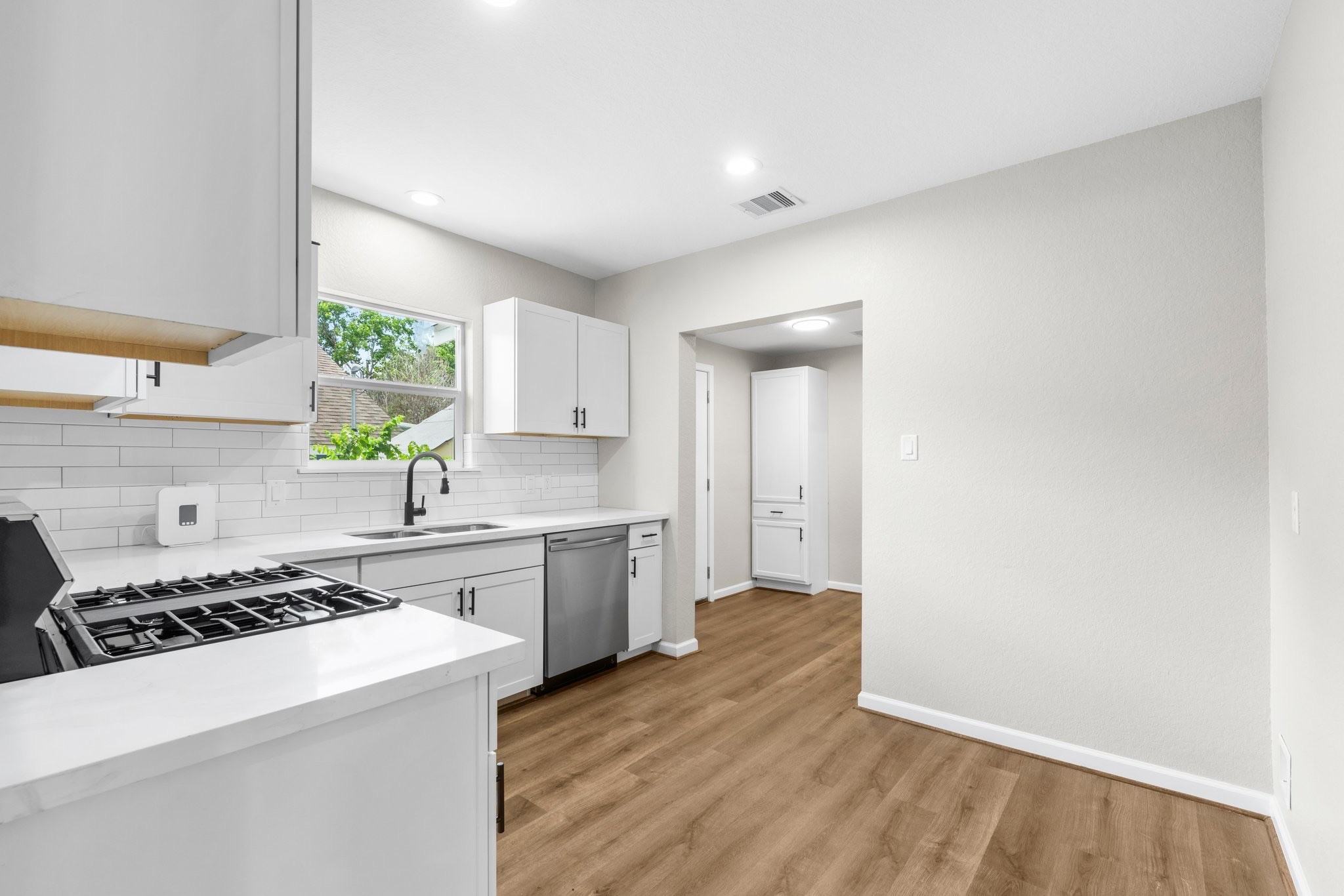 3106 Michigan Street Baytown, TX 77520 - Photo 7 of 14 a kitchen with a sink a stove cabinets and wooden floor