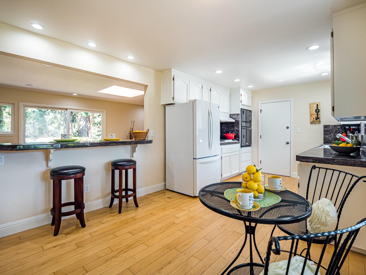 237 Siesta Drive Aptos, CA 95003 - Photo 9 of 43 a kitchen with stainless steel appliances kitchen island granite countertop a dining table chairs and a refrigerator