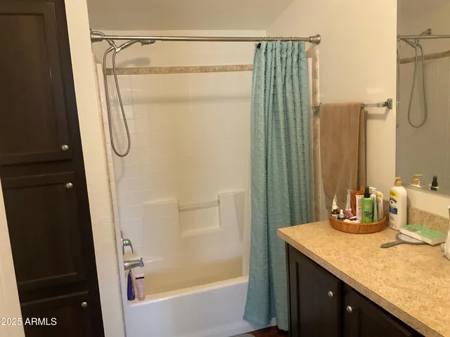 a bathroom with a granite countertop bathtub shower sink and vanity
