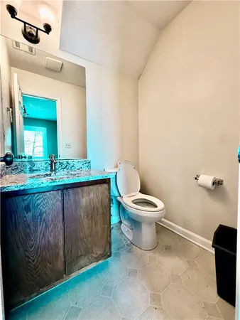 a bathroom with a toilet a sink and mirror