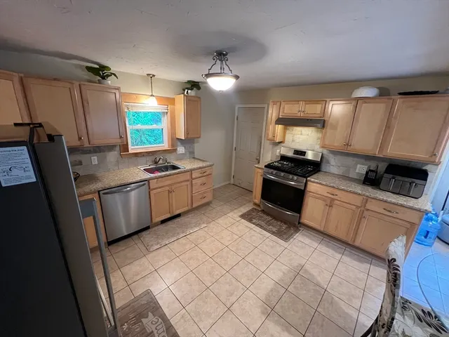 a kitchen with a sink a refrigerator and cabinets