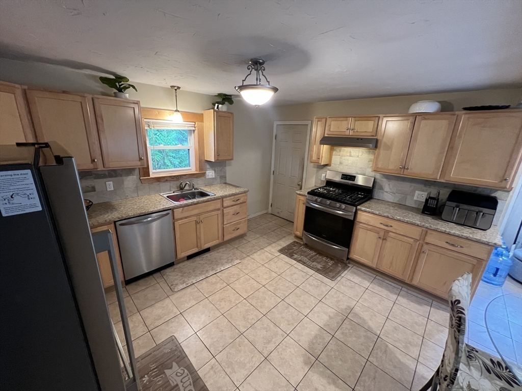 40 Chestnut Street Milford, MA 01757 - Photo 4 of 19 a kitchen with a sink a refrigerator and cabinets