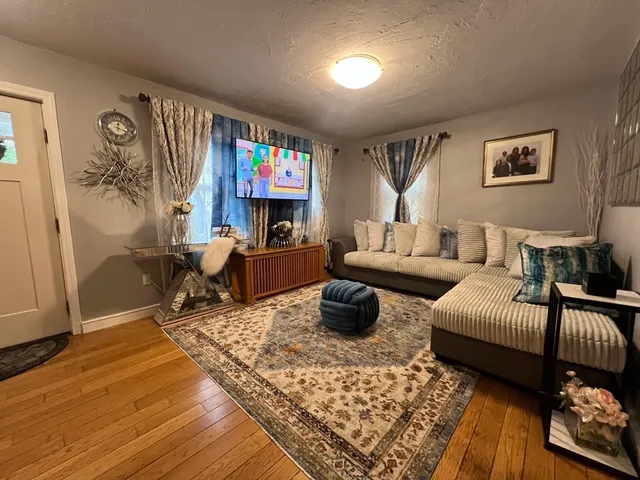 a living room with furniture a rug and a flat screen tv