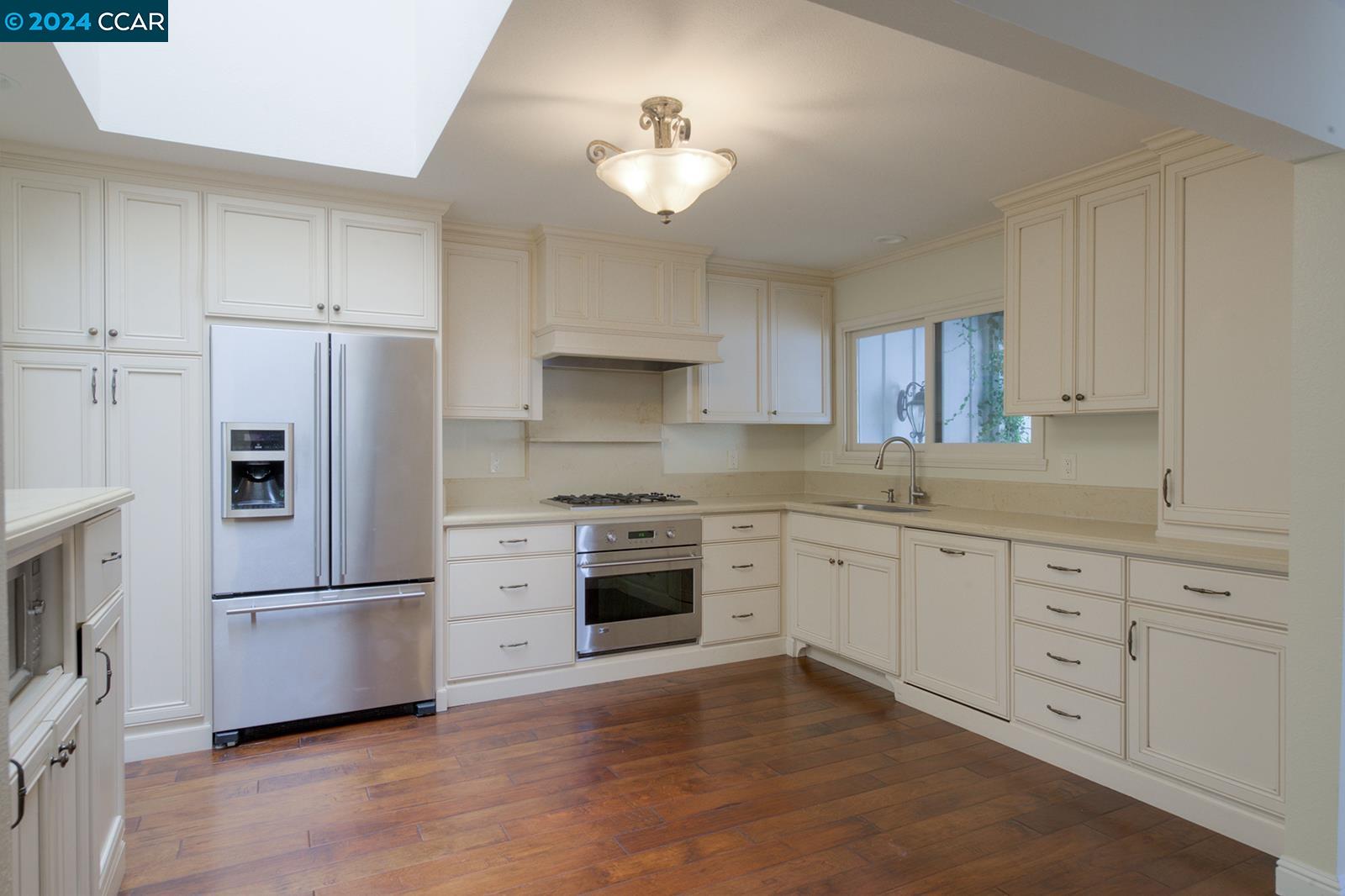 564 Cambrian Way Danville, CA 94526 - Photo 5 of 13 a kitchen with granite countertop a refrigerator oven a sink dishwasher and white cabinets with wooden floor