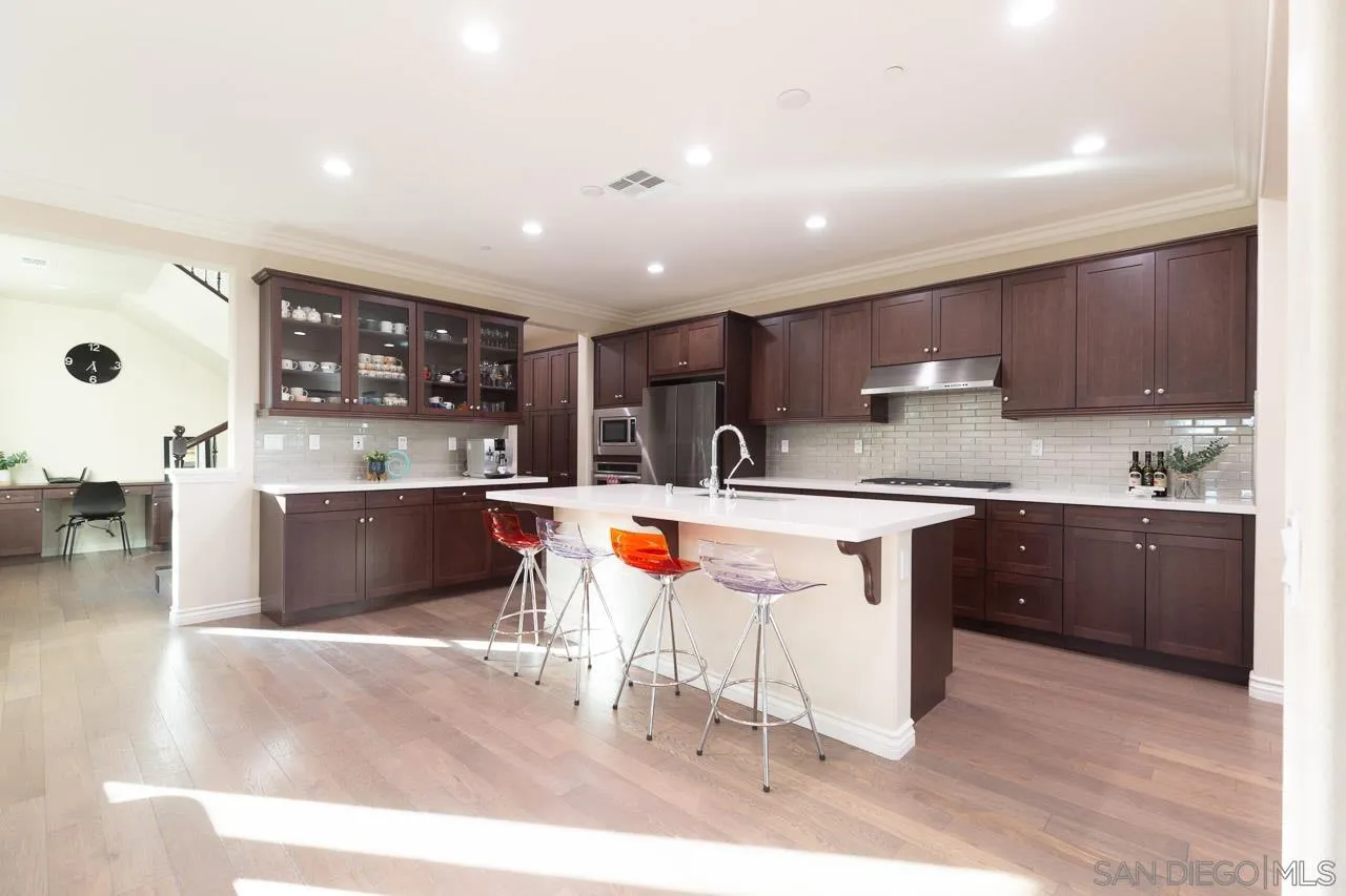 15622 Potomac Ridge Road San Diego, CA 92127 - Photo 11 of 49 a kitchen with stainless steel appliances kitchen island granite countertop a sink and cabinets