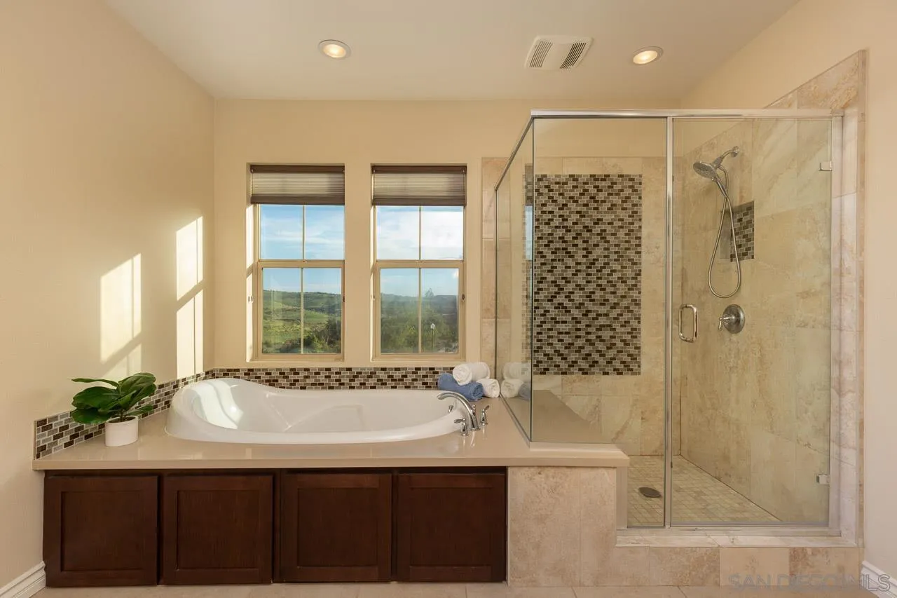15622 Potomac Ridge Road San Diego, CA 92127 - Photo 27 of 49 a bathroom with a granite countertop sink a mirror and a bathtub