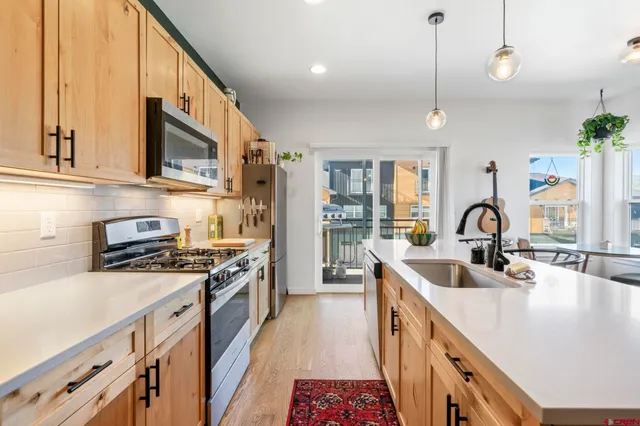 a kitchen with stainless steel appliances granite countertop a sink and a stove