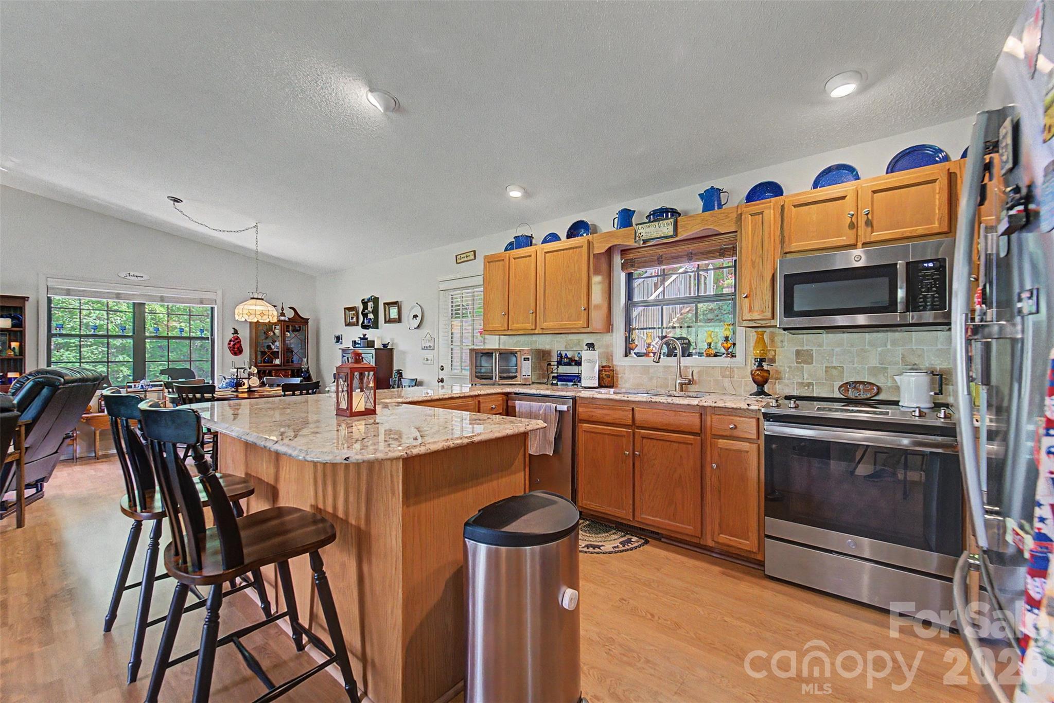 531 Reserve Road Franklin, NC 28734 - Photo 8 of 42 a kitchen with stainless steel appliances granite countertop a stove a sink dishwasher and a refrigerator with wooden floor
