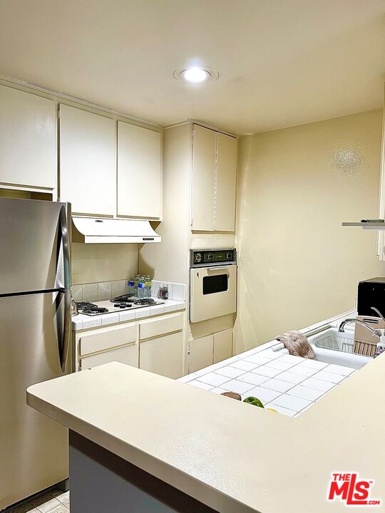 1935 Alpha Road, Unit 114 Glendale, CA 91208 - Photo 7 of 12 a kitchen with a sink a stove and refrigerator
