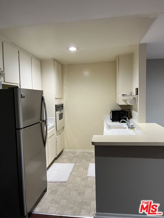 1935 Alpha Road, Unit 114 Glendale, CA 91208 - Photo 8 of 12 a kitchen with a refrigerator and a stove