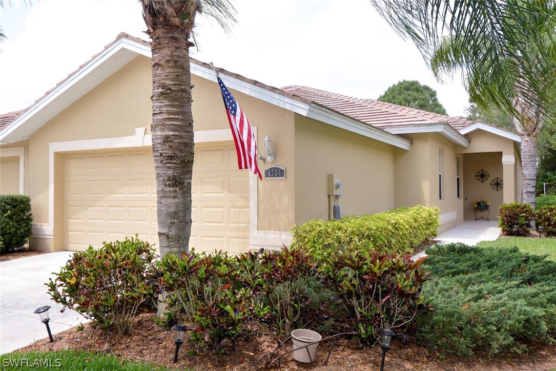 4704 Fairloop Run Lehigh Acres, FL 33973 - Photo 1 of 25 a front view of a house with garden
