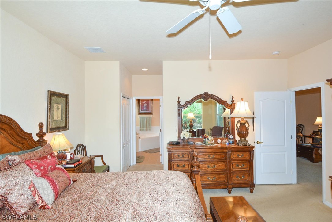 4704 Fairloop Run Lehigh Acres, FL 33973 - Photo 16 of 25 a bedroom with a bed and ceiling fan