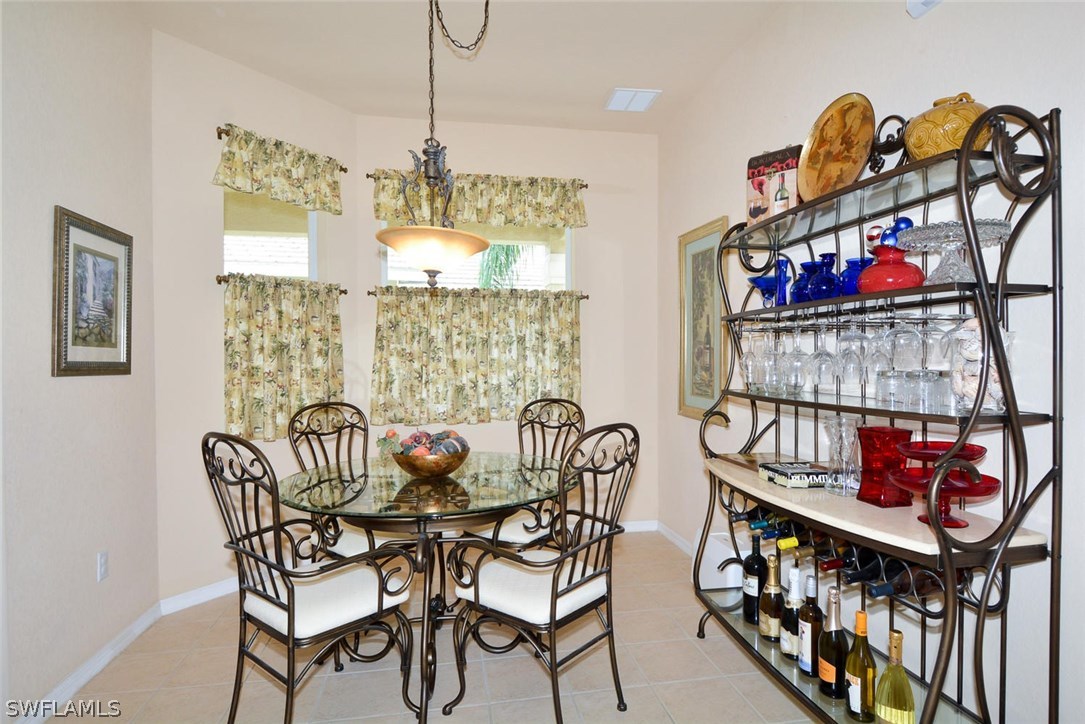 4704 Fairloop Run Lehigh Acres, FL 33973 - Photo 8 of 25 a view of a dining room with furniture and chandelier