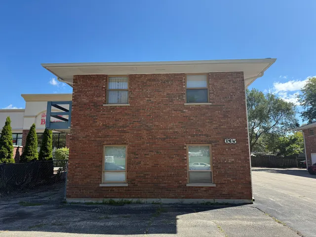 a view of a brick house with a yard