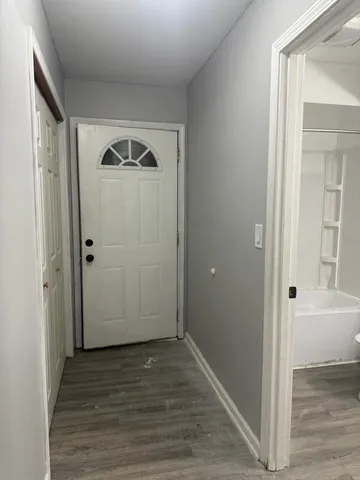a view of a hallway with wooden floor and entryway