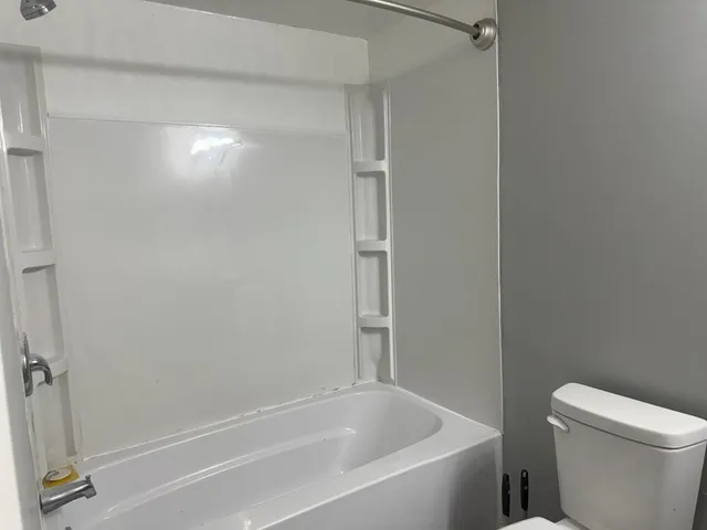 a white bath tub sitting next to a toilet