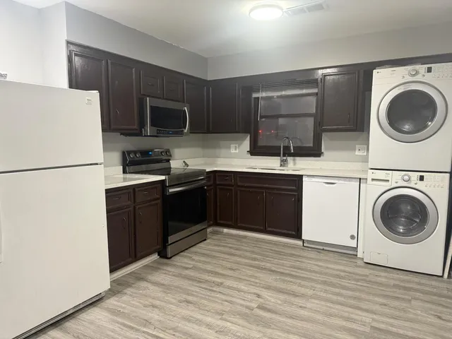 a kitchen with stainless steel appliances granite countertop a refrigerator a stove top oven a sink and dishwasher