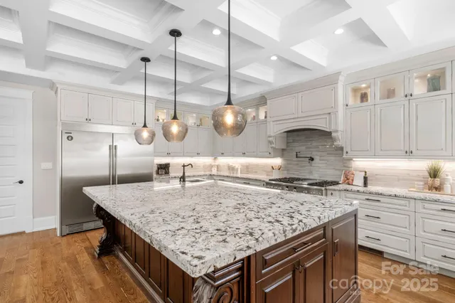 a kitchen with kitchen island granite countertop wooden cabinets and a refrigerator