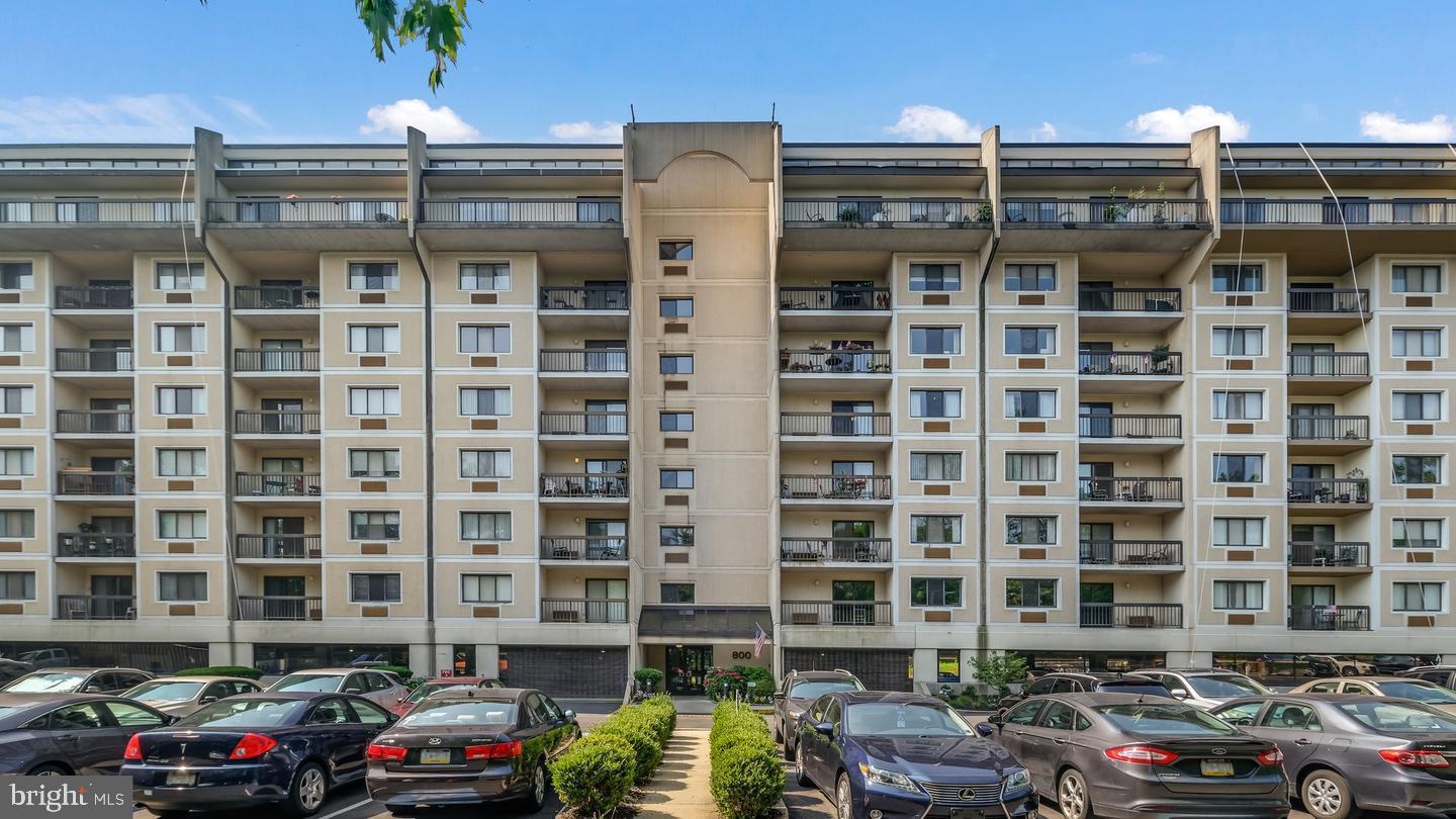 a front view of a building with parking space and a car parked beside it