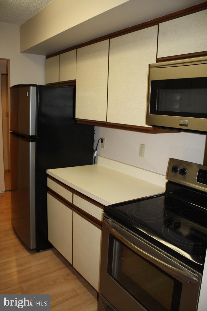 800 Avondale Road, Unit 6C Wallingford, PA 19086 - Photo 9 of 25 a kitchen with stainless steel appliances a sink stove and refrigerator