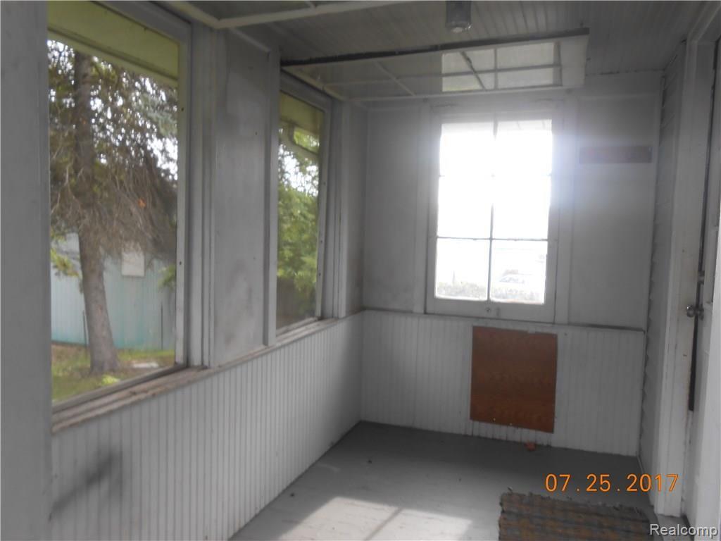 Enclosed back porch with unique flip up farm style windows.