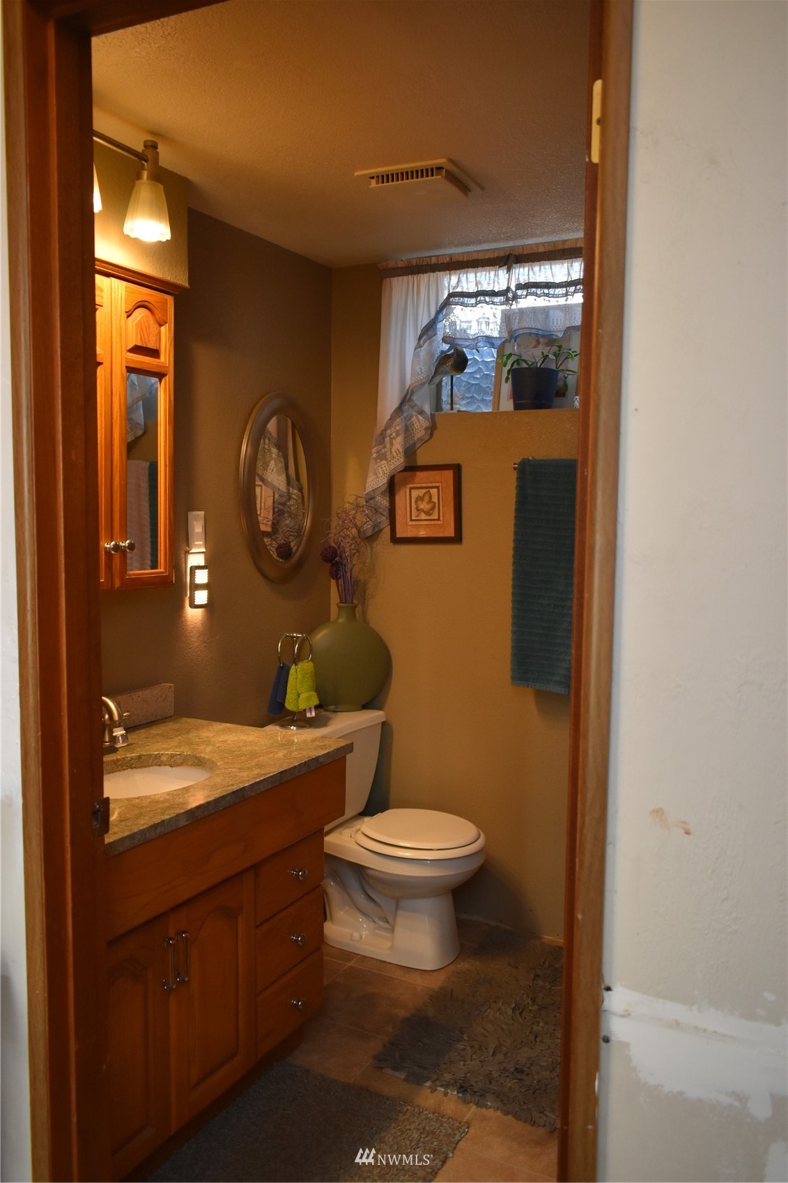 819 Sheridan Road Bremerton, WA 98310 - Photo 25 of 40 a bathroom with a granite countertop toilet a sink and a mirror