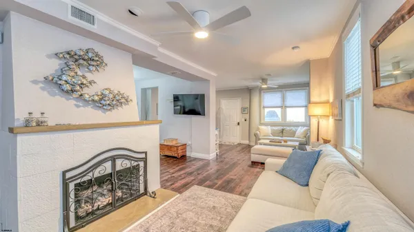 a living room with furniture a fireplace and a large window