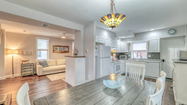 a living room with kitchen island furniture and a chandelier