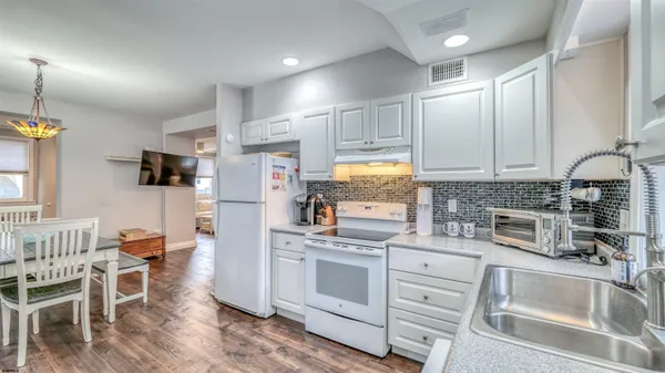 a kitchen with white cabinets and white appliances