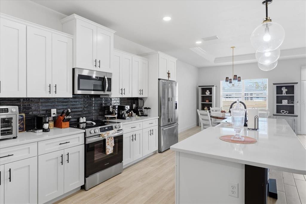 1054 Southwest 67th Street Gainesville, FL 32607 - Photo 11 of 37 a kitchen with kitchen island a sink stainless steel appliances and cabinets