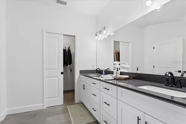 a spacious bathroom with double sink and a mirror