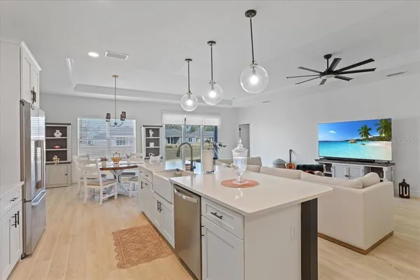 a view of a dining room and livingroom with furniture wooden floor a chandelier