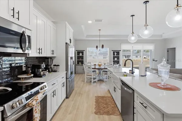 a large kitchen with lots of counter space a sink appliances and cabinets