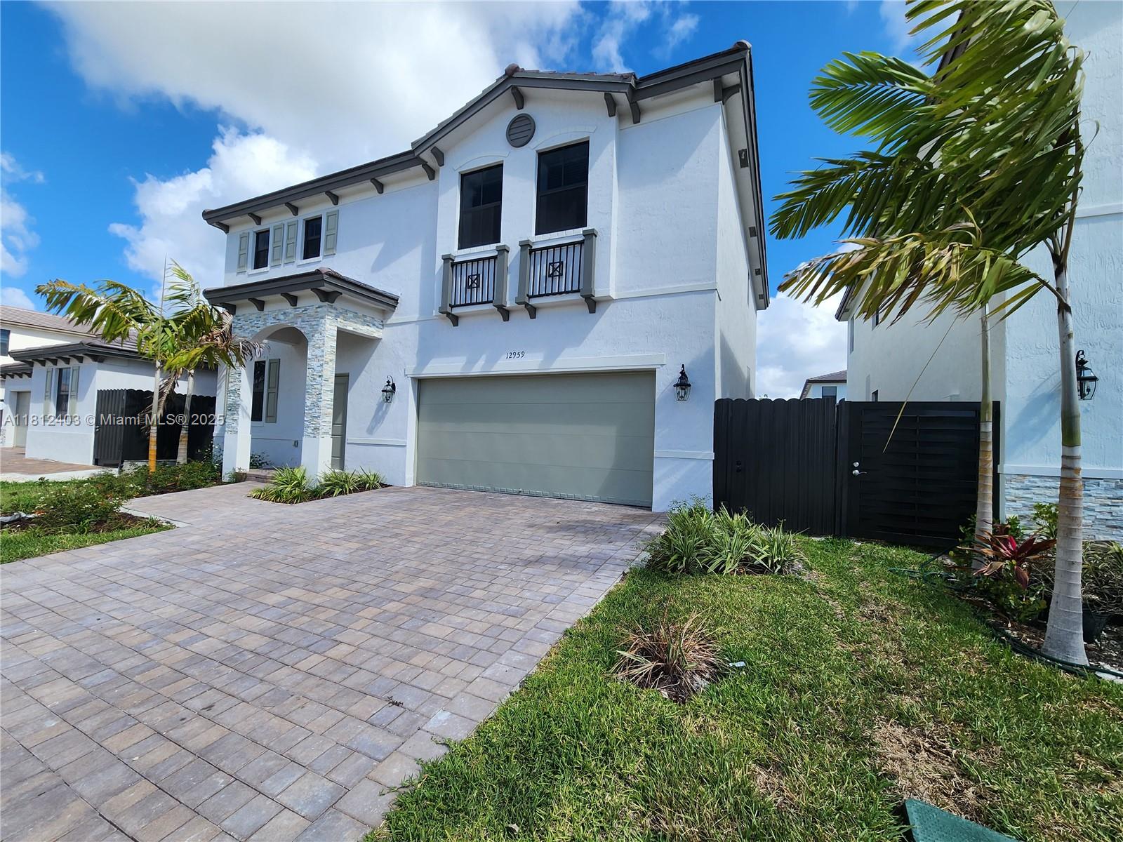 12959 Southwest 229th Lane Miami, FL 33170 - Photo 27 of 28 a front view of a house with a yard and garage