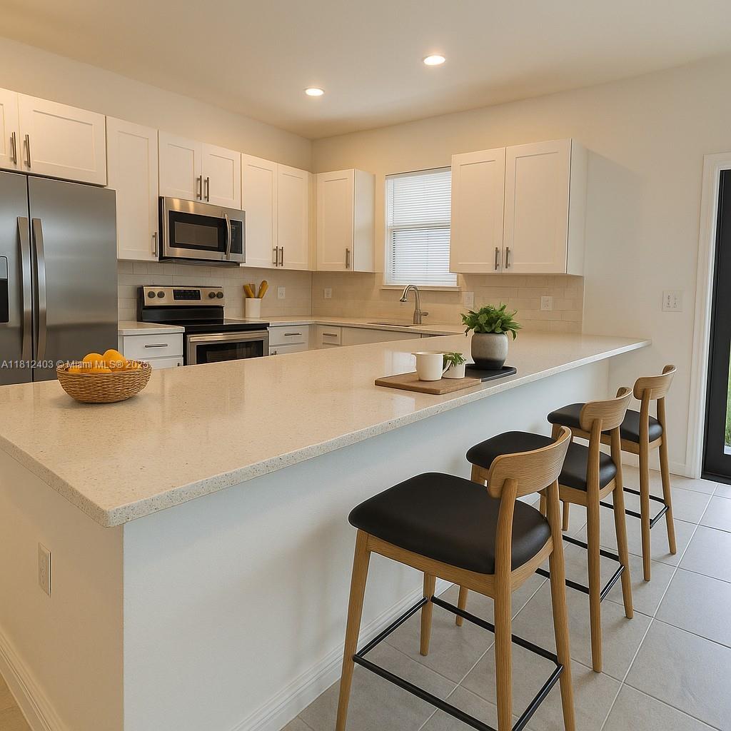 12959 Southwest 229th Lane Miami, FL 33170 - Photo 6 of 28 a kitchen with stainless steel appliances a stove a sink a refrigerator white cabinets and chairs