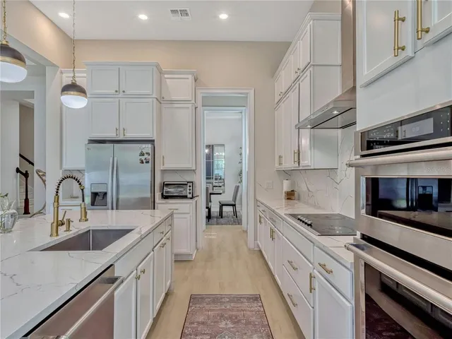 a large kitchen with stainless steel appliances and a sink