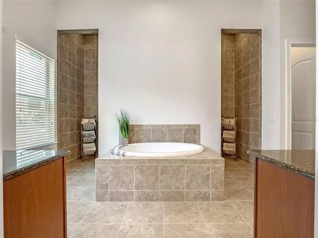 a spacious bathroom with a tub sink and mirror