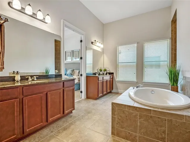 a bathroom with a tub sink and mirror