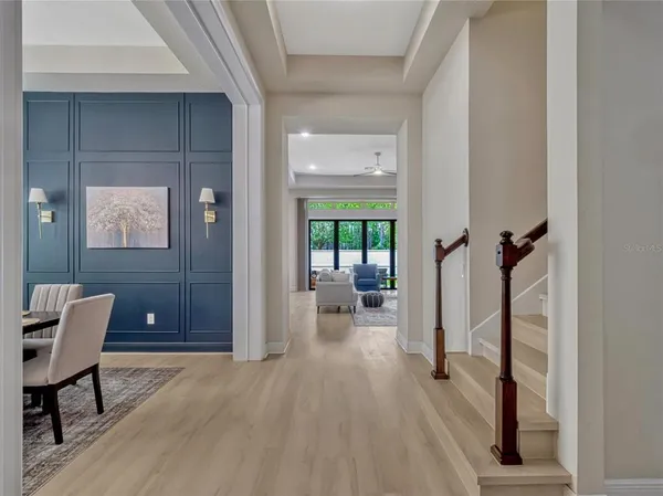 a view of a hallway with bathroom and wooden floor