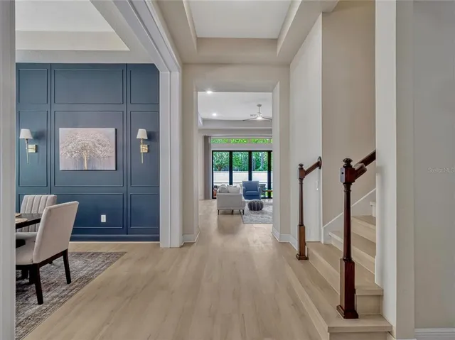 a view of a hallway with bathroom and wooden floor
