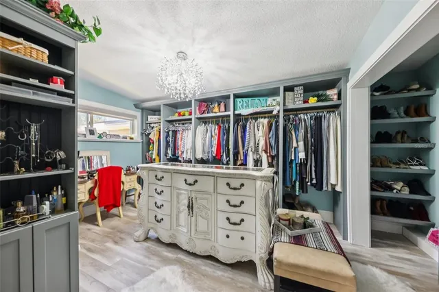 a view of walk in closet with clothes and shoes