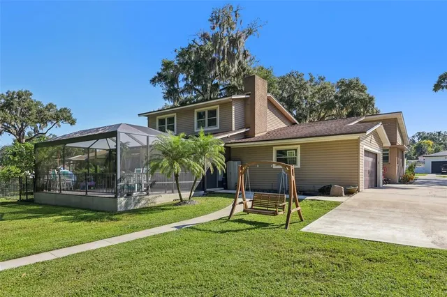 a view of a house with backyard and a tree